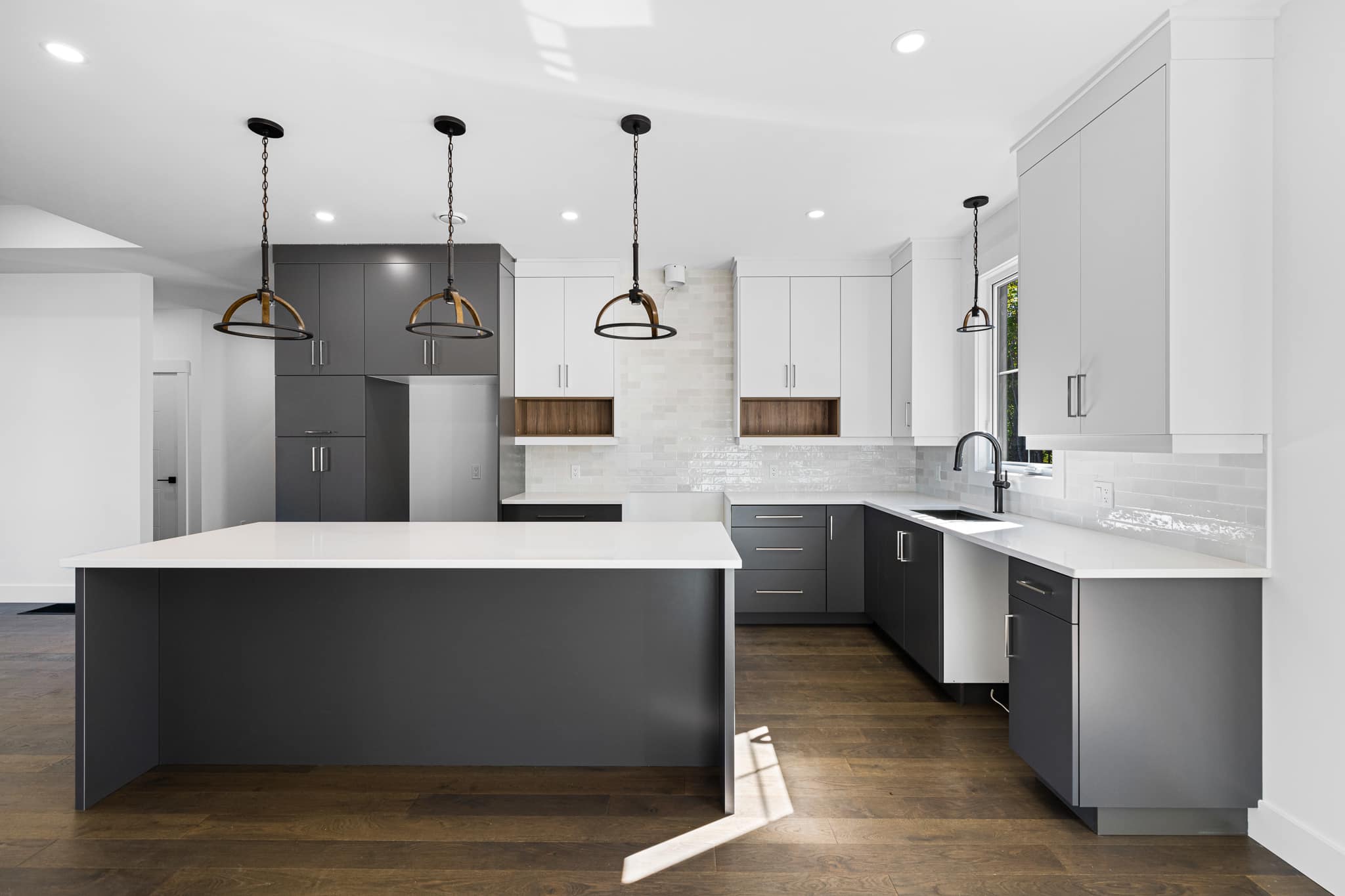 Every Extreme Kitchen project is completed using the same process, and we want you to know what to expect. New construction large open concept kitchen with oversized island. Stunning upper white cabinets, grey lowers, and brass light fixtures.
