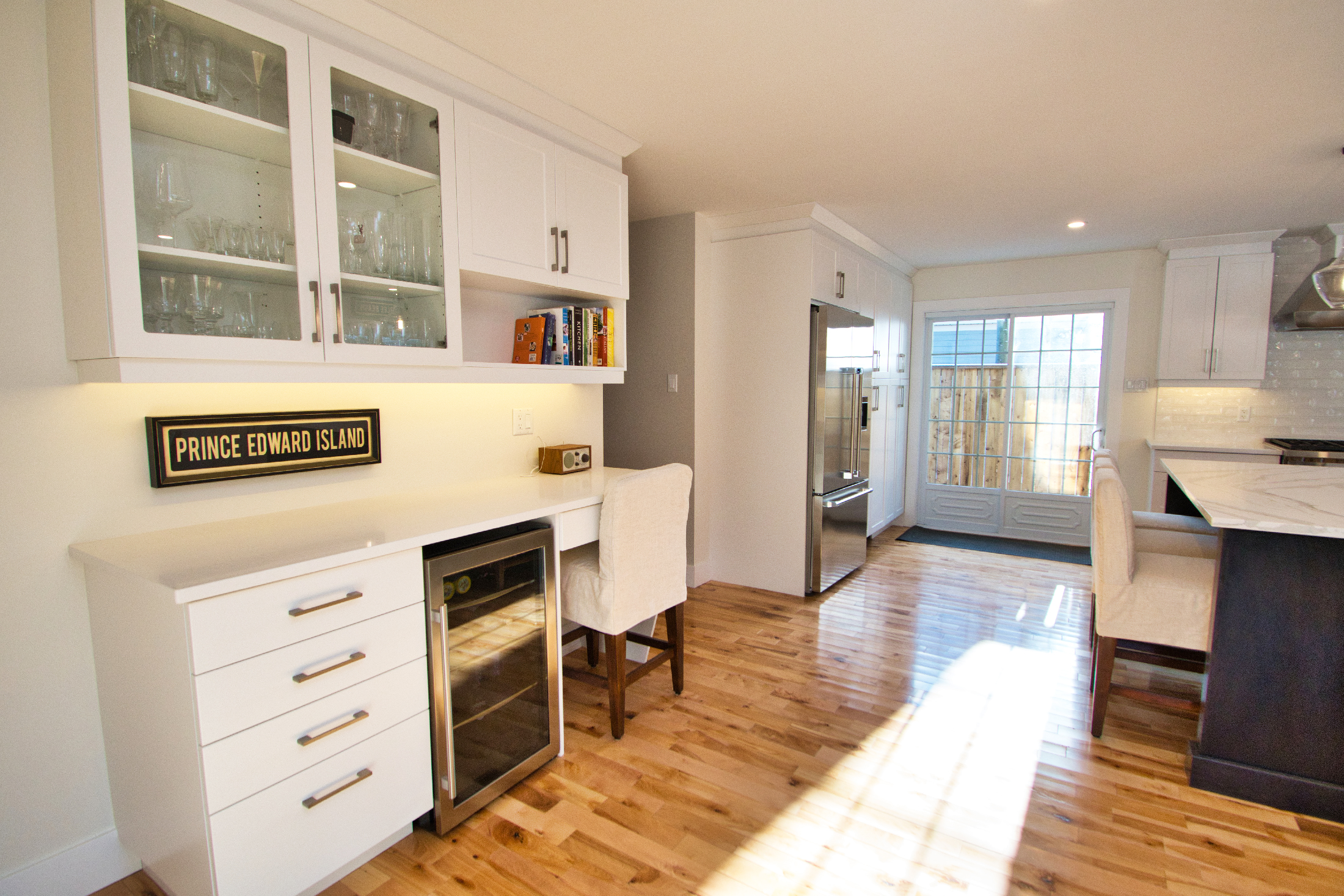 Large layout kitchen, facing a wall with dedicated desk space, upper cabinet storage, under counter wine fridge, and stainless steel fridge.